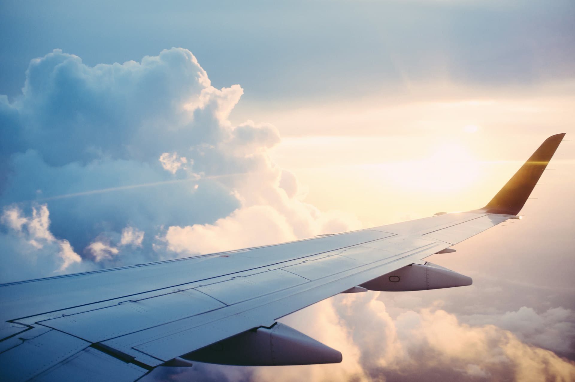 An aeroplane wing above the clouds at sunrise